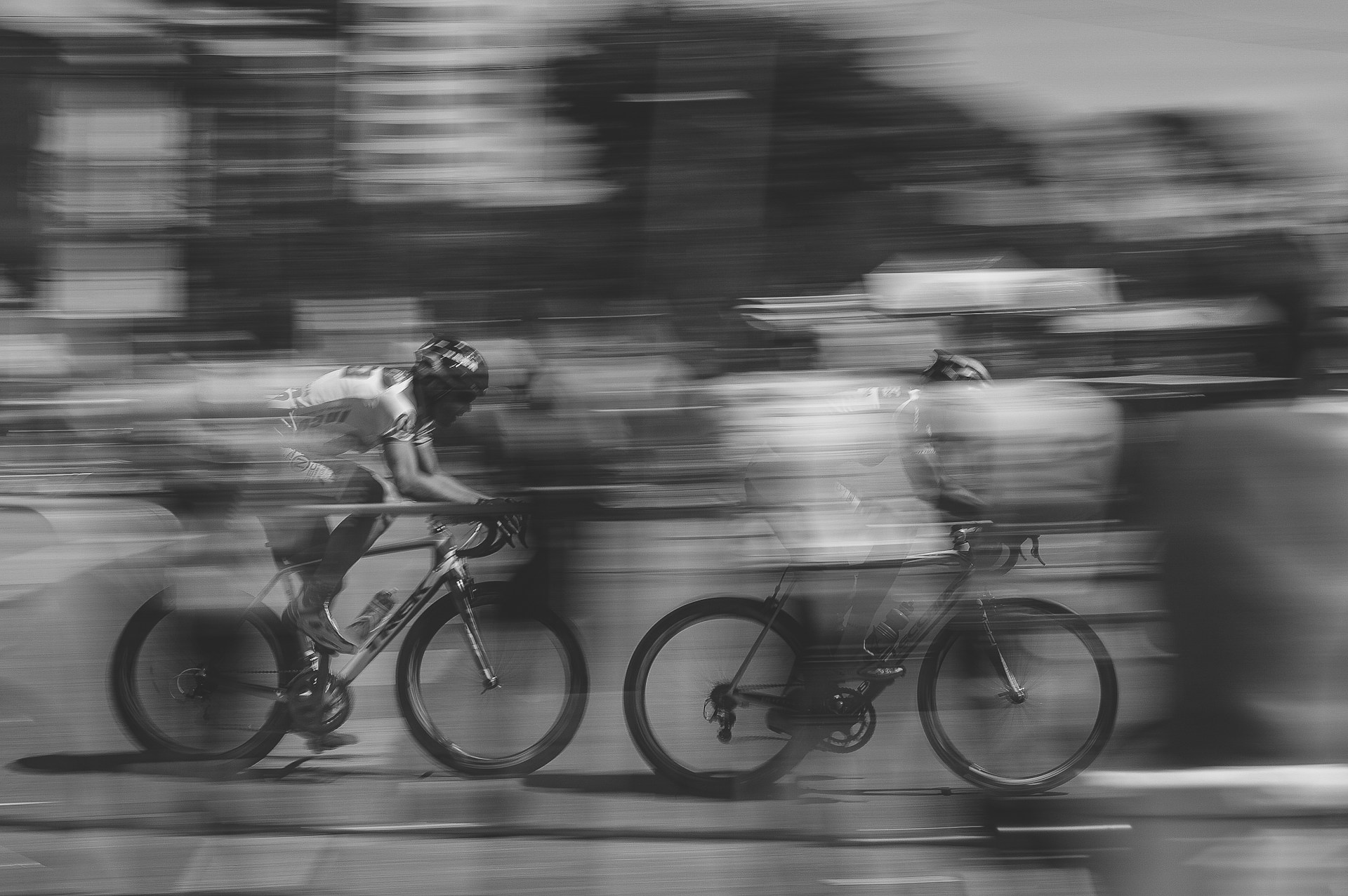 Blurry shot of two people racing on bikes.  Photo by Maico Amorim on Unsplash