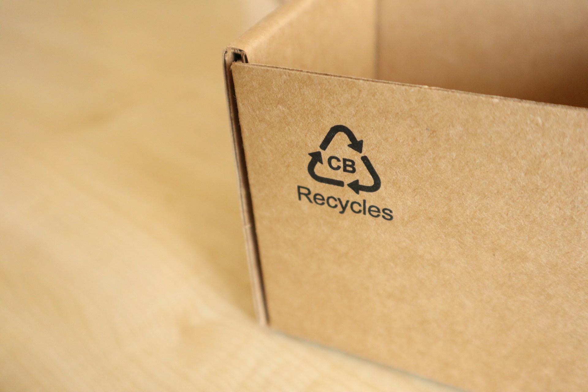 A close-up of a cardboard box with the triangular recycling logo on the side.  Photo by Ochir-Erdene Oyunmedeg on Unsplash.