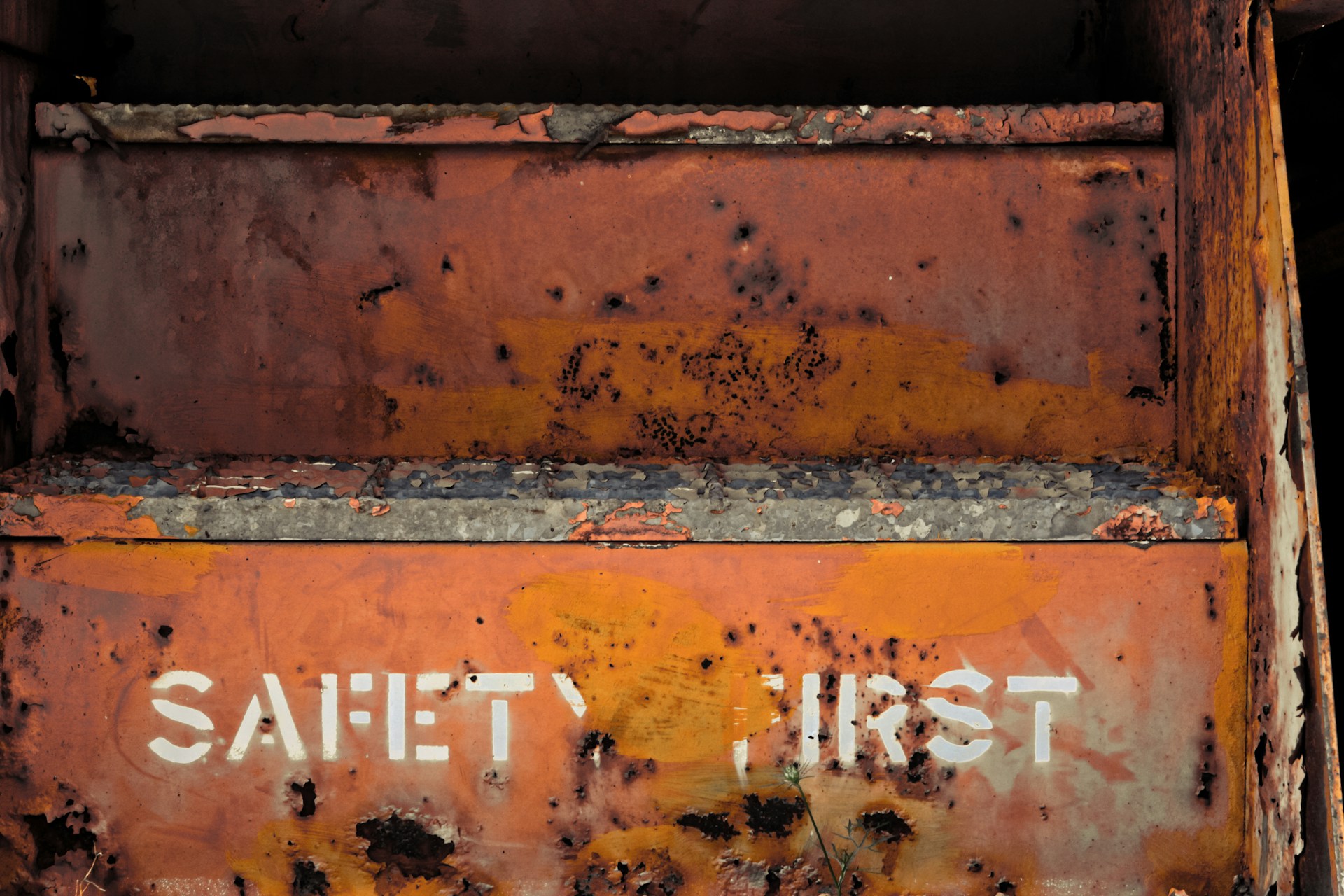 A metal box with the words 'SAFETY FIRST' painted on it.  The box is rusting in places and the paint is flaking.  Photo by Joe Dudeck on Unsplash